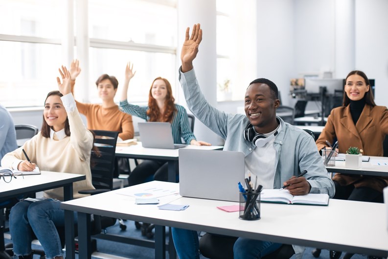 Presentation, Convention Concept. Portrait of smiling international people participating in seminar at modern office, raising hands up to ask question or to volunteer, diverse group sitting at tables